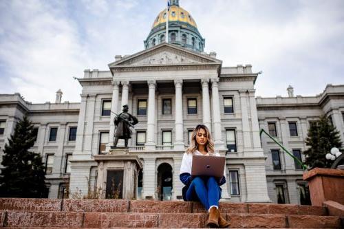 Fatema Tasnim studies with a laptop in front of the Denver Capitol Building