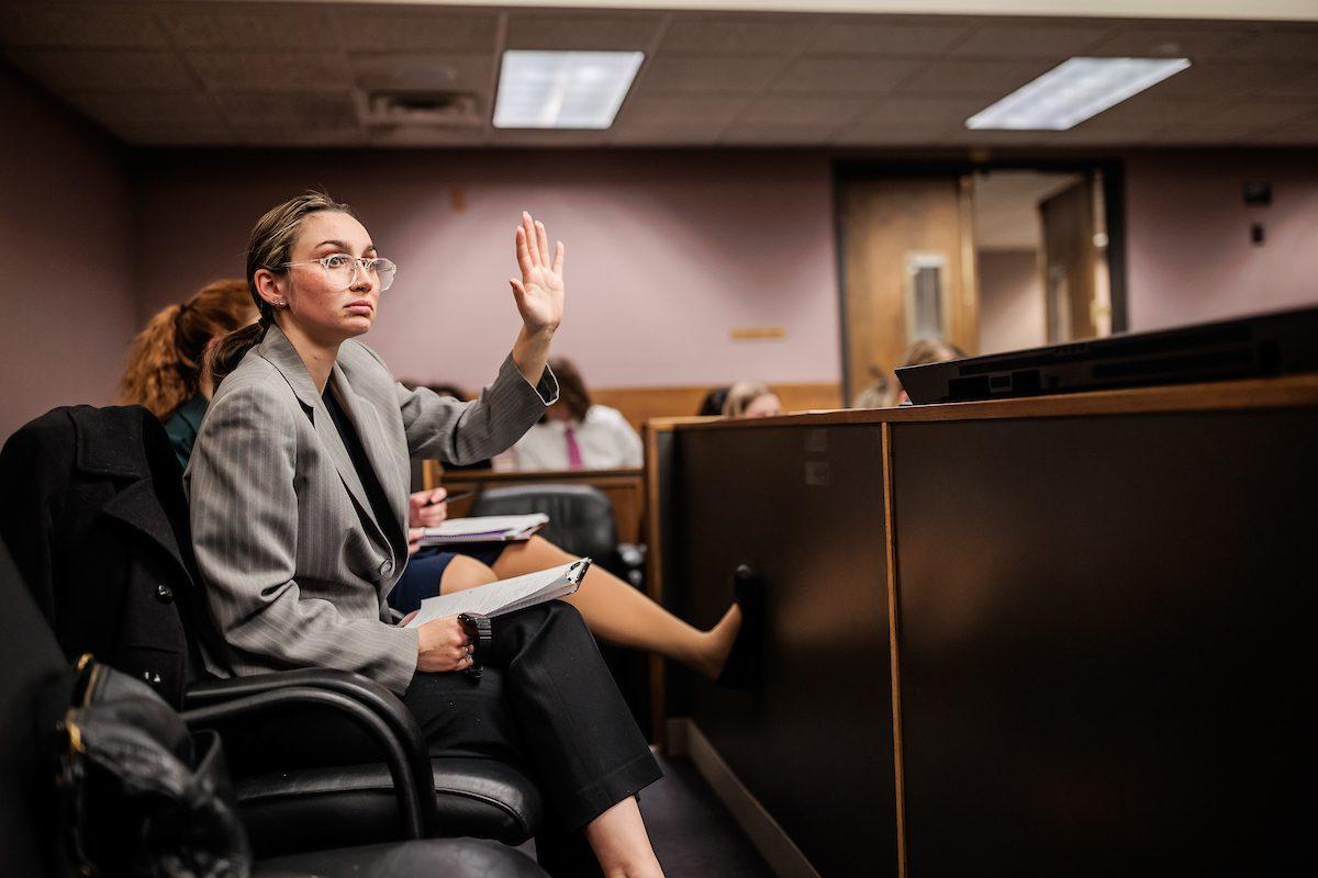 A student raises their hand during Mock Trial